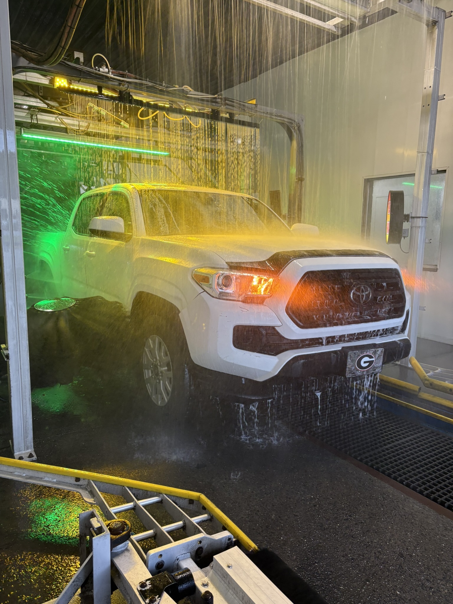 White Toyota Tacoma inside the Stroll N Shine wash tunnel